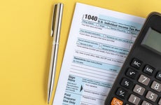 A U.S. IRS Form 1040 tax return alongside a pen and calculator