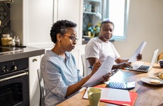 A couple works on taxes at their kitchen table