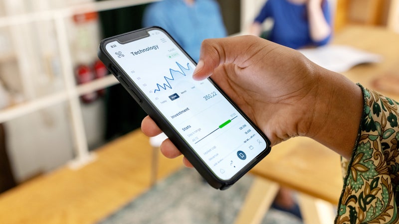 Close-up of woman trading stock online on mobile phone