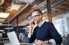 A middle aged White guy sits at an office desk