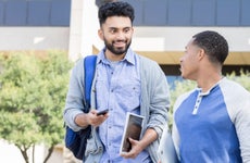 Male friends walk on a college campus.