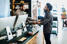 Man handing cloths to cashier