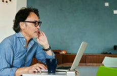 Man working on laptop and drinking coffee