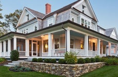 Exterior view of custom built home with exterior lighting and manicured landscaping.