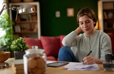 Women using digital tablet to check her finances at home office