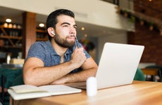 freelance worker in the cafe thinking about a new idea while doing remote work using his laptop