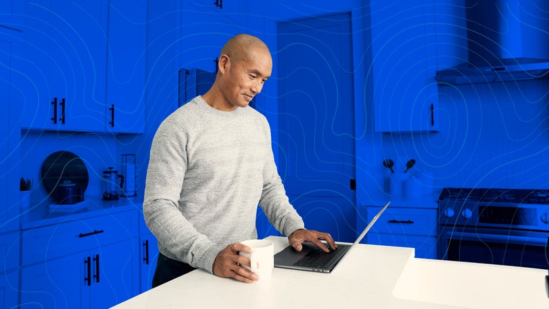 man working on his laptop in the kitchen