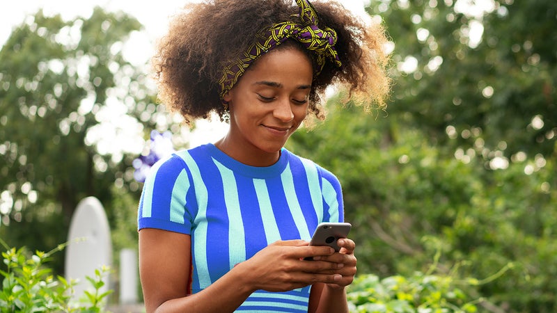 Woman using smart phone on wall