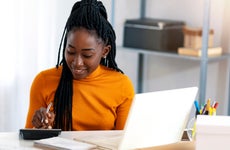 A Black woman using a calculator.